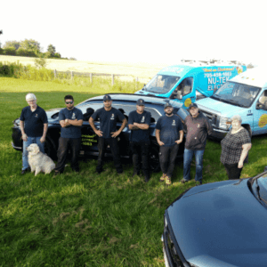 Nu-Tek Electric team smiling in front of their company vehicles
