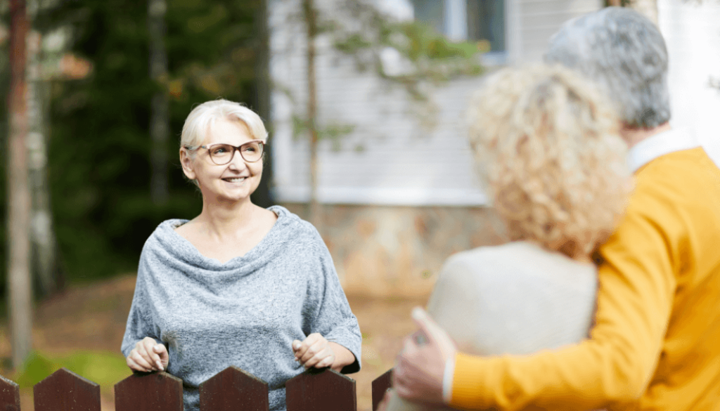 Neighbours talking to each other outside over a fence