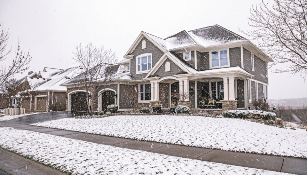 A large home surronded by snow in a winter storm